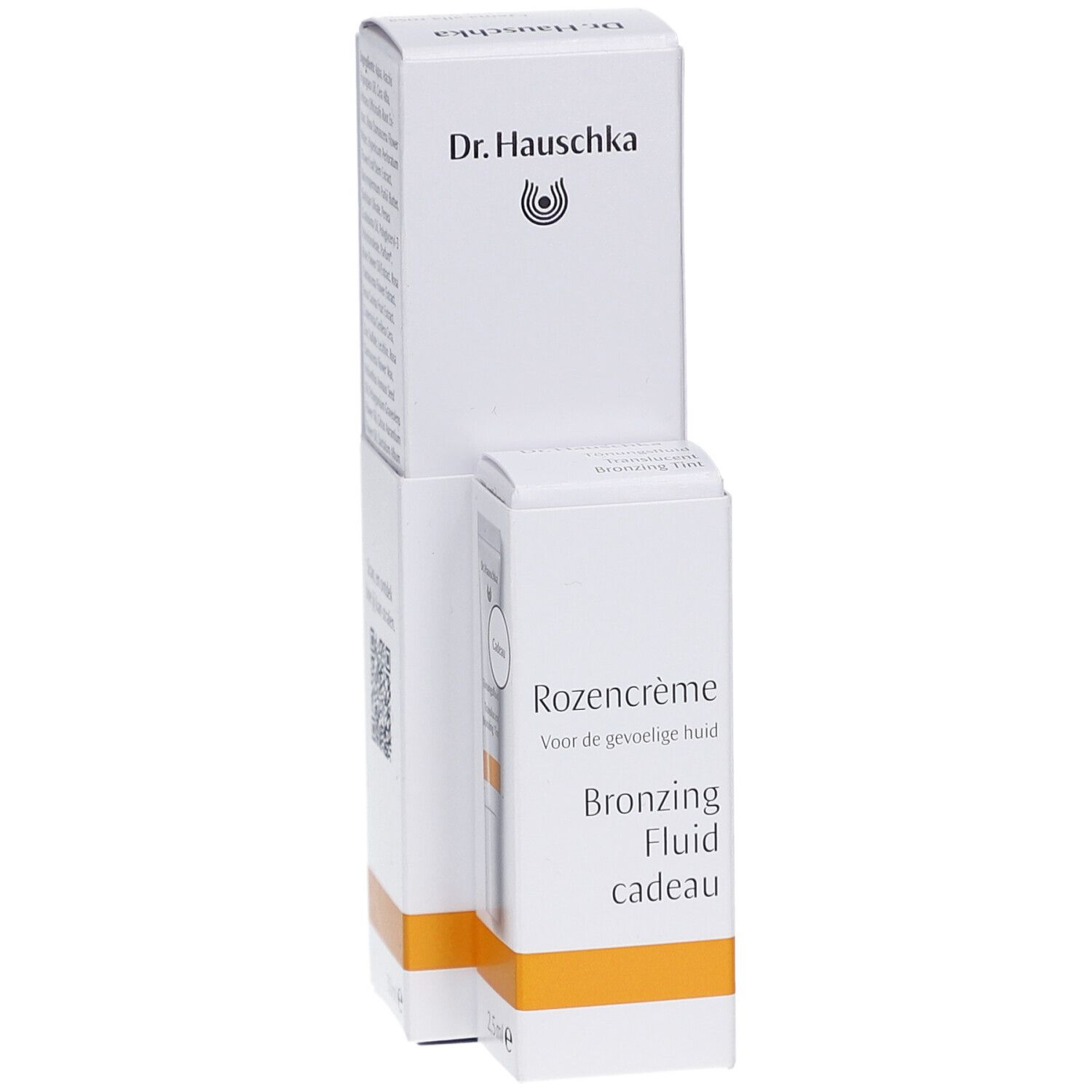 Emballage blanc Dr. Hauschka. Texte: Rozencrème, Bronzing Fluid cadeau. Bande orange.