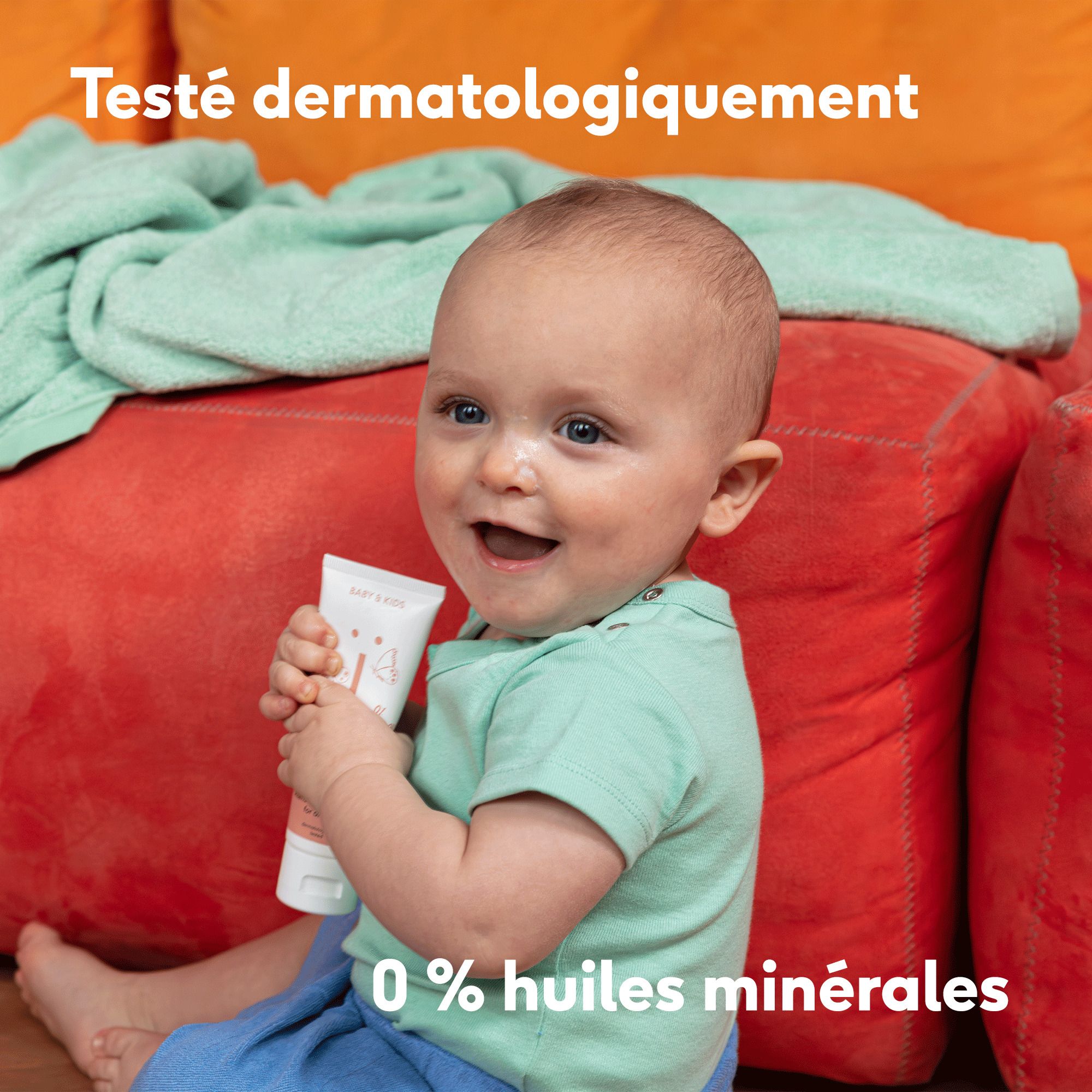 Bébé assis par terre tenant une crème. Logo Vegan.