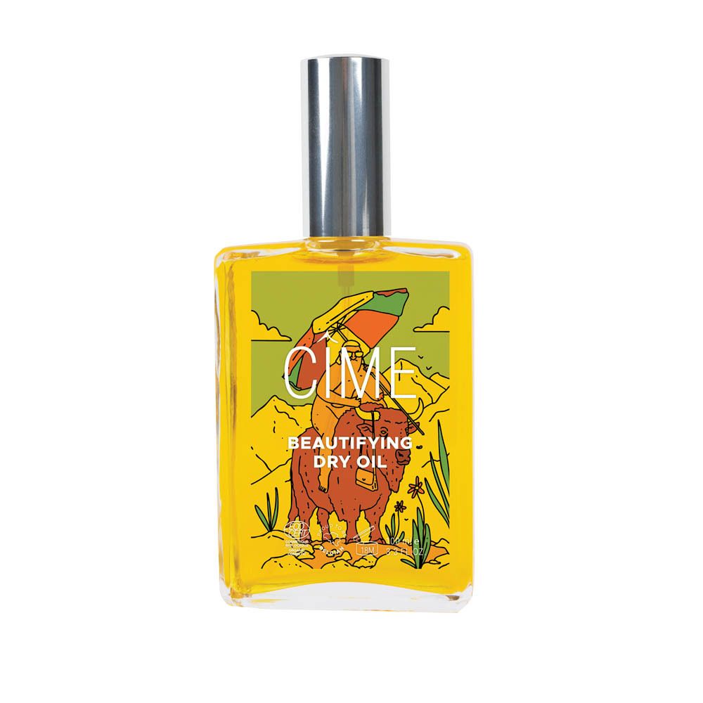 Flacon en verre jaune avec bouchon argenté. Étiquette avec illustration et texte : CIME, Beautifying Dry Oil.