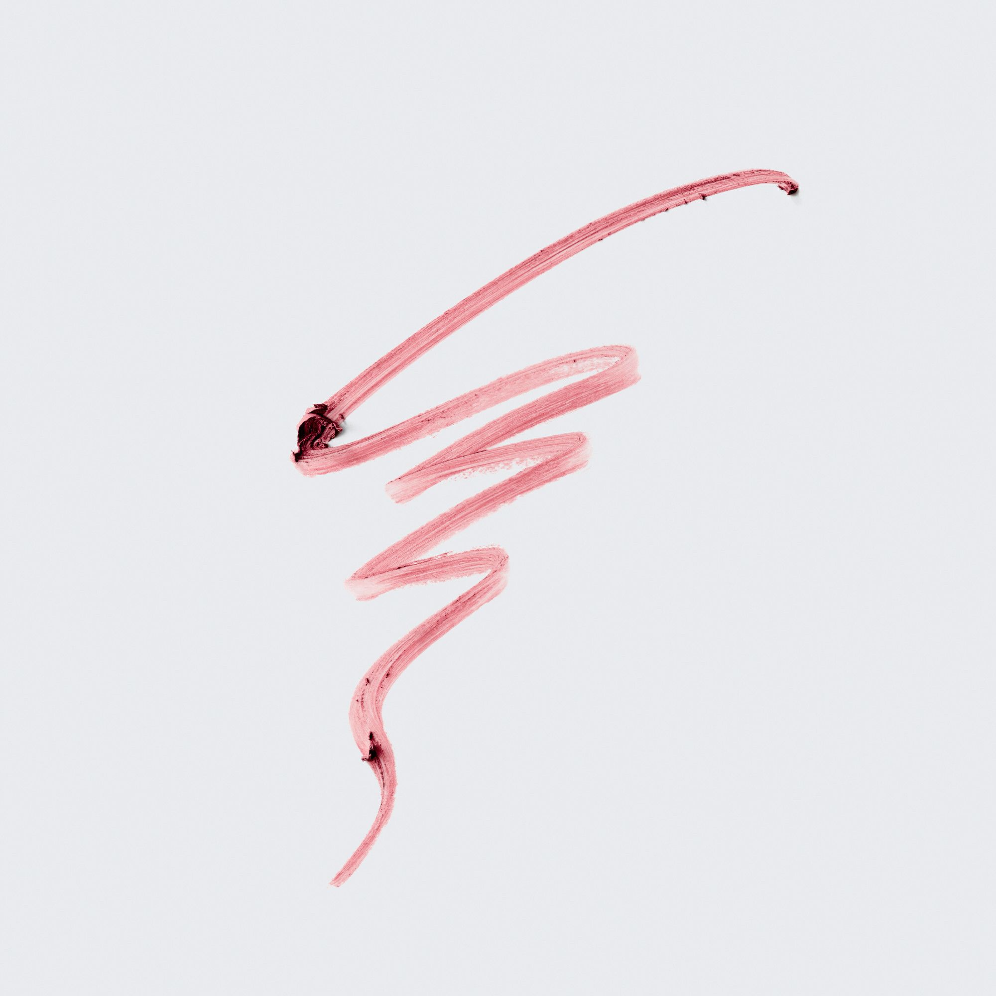 Trait de rouge à lèvres rose sur fond clair. Texture et couleur du produit visibles.