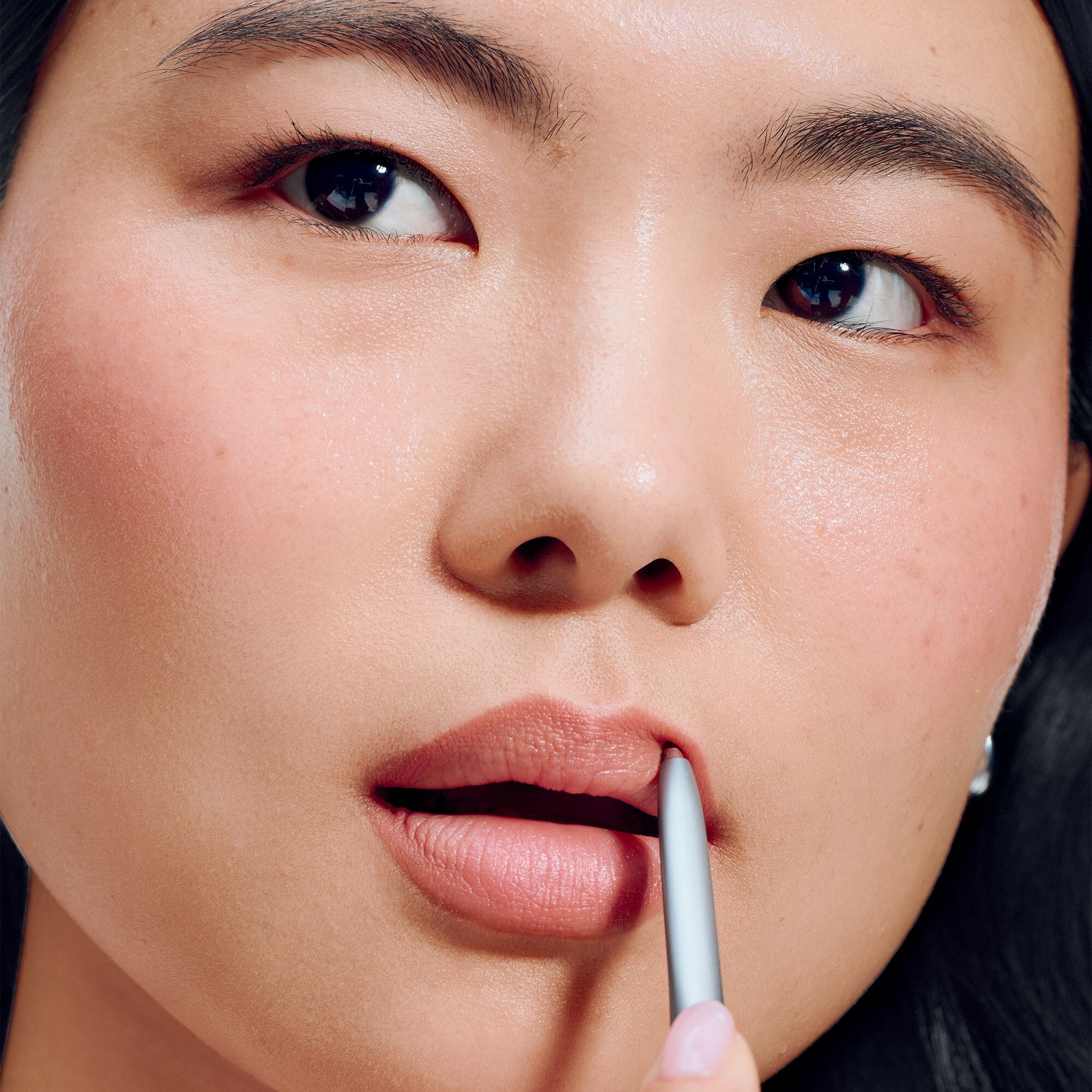 Gros plan d'une femme utilisant Clinique Quickliner™ For Lips. Produit en cours d'utilisation.