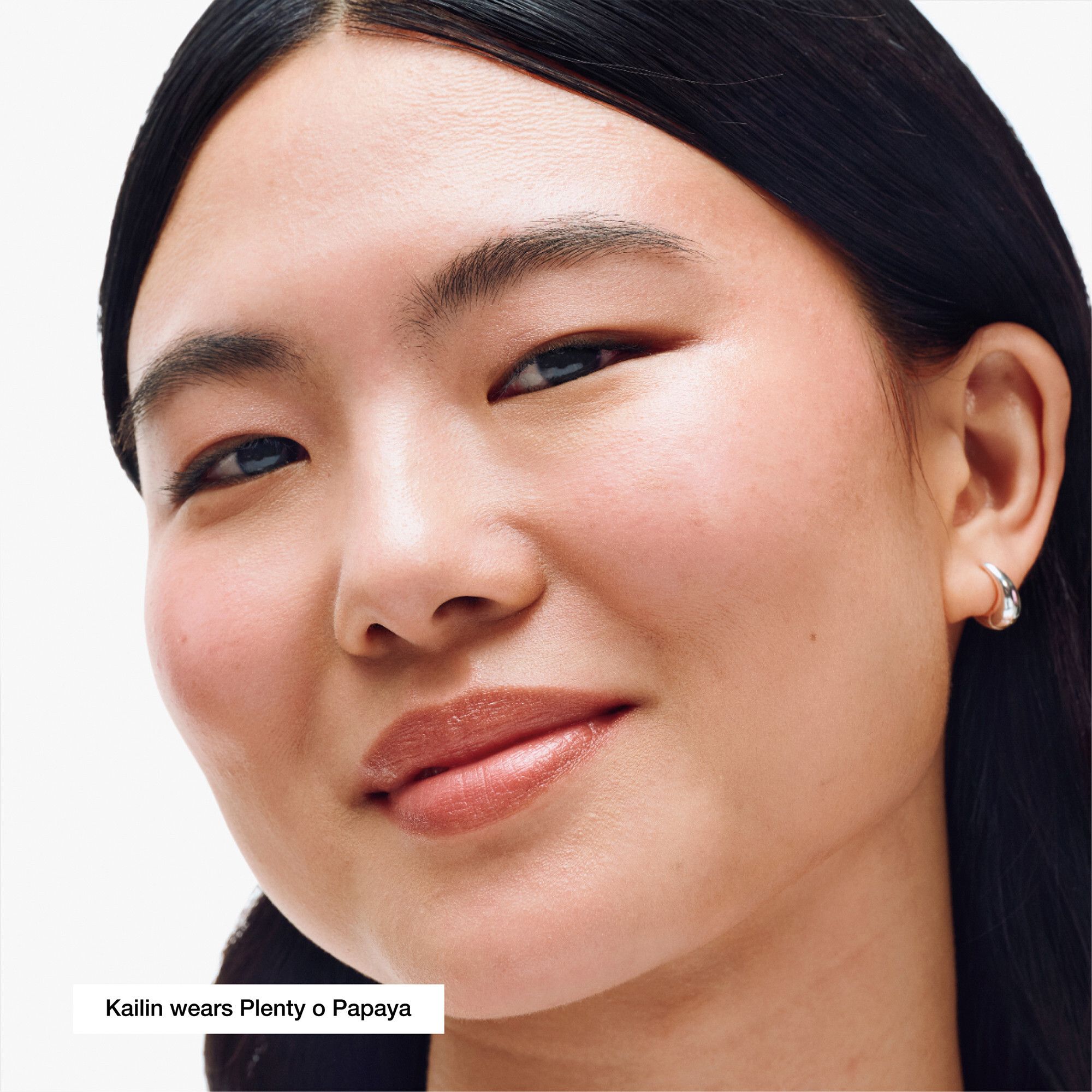 Visage d'une femme avec Clinique Chubby Stick™ Baume couleur joues Plenty O' Papaya. Teinte de peau.