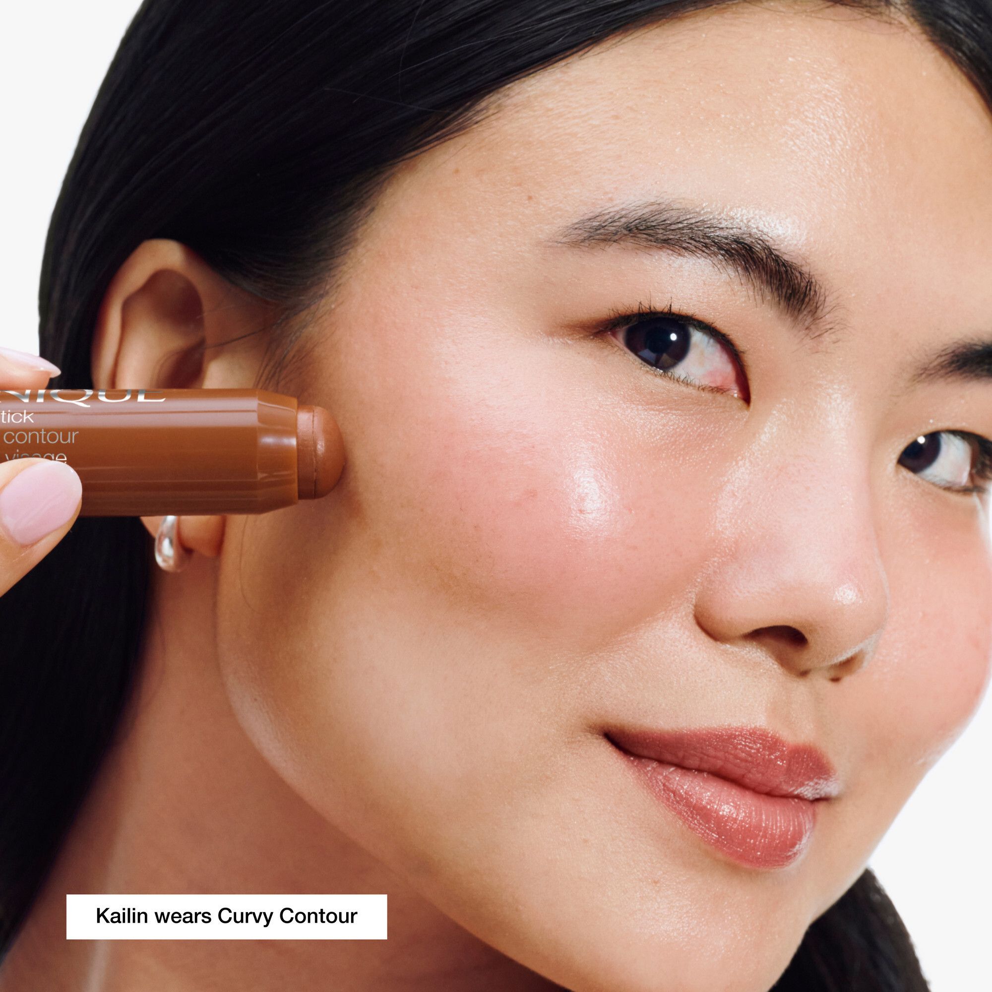 Femme portant Clinique Chubby Stick™ Contour sculptant 01 Curvy Contour. Couleur marron sur la peau.