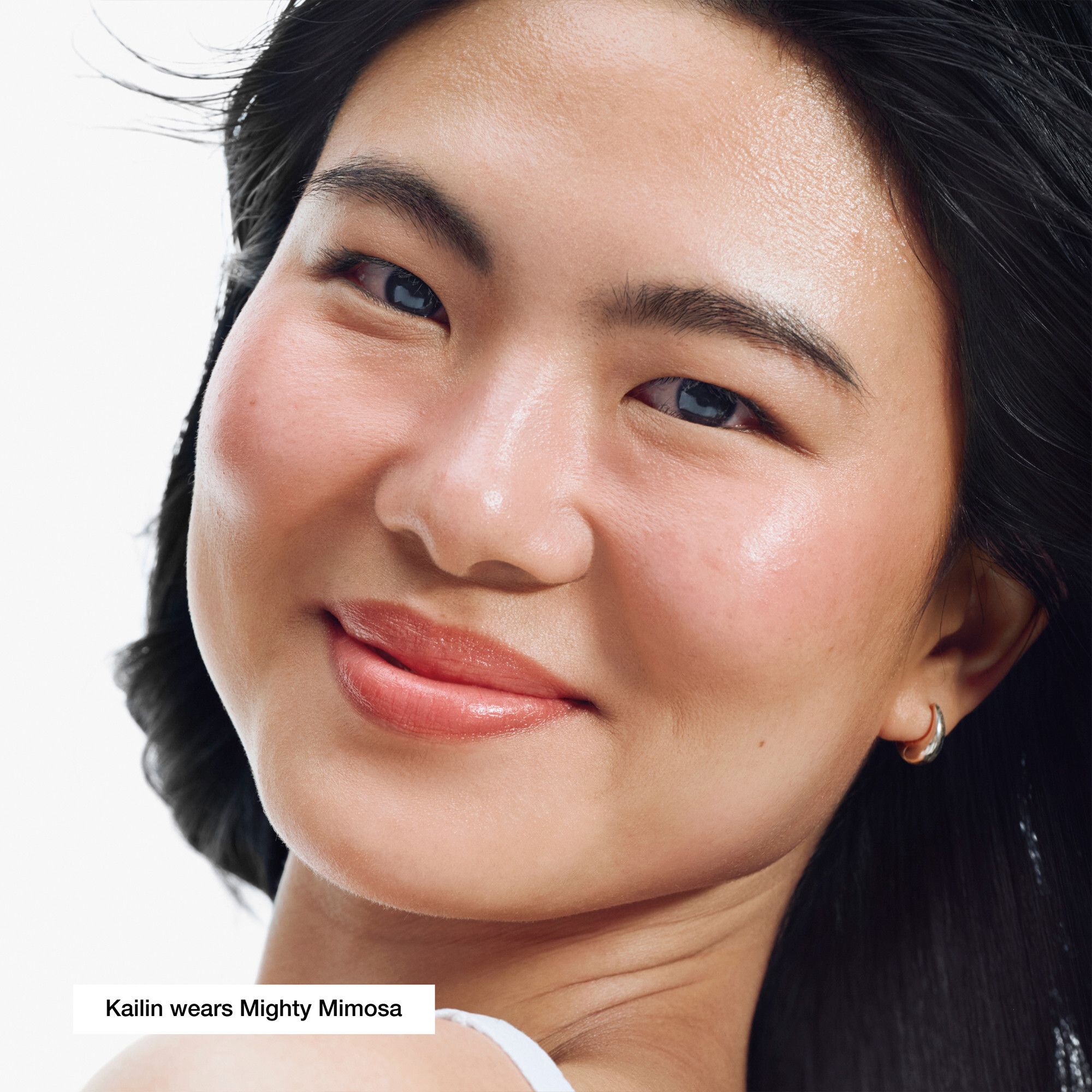 Femme avec la couleur de lèvres Mighty Mimosa. Texte: Kailin wears Mighty Mimosa.