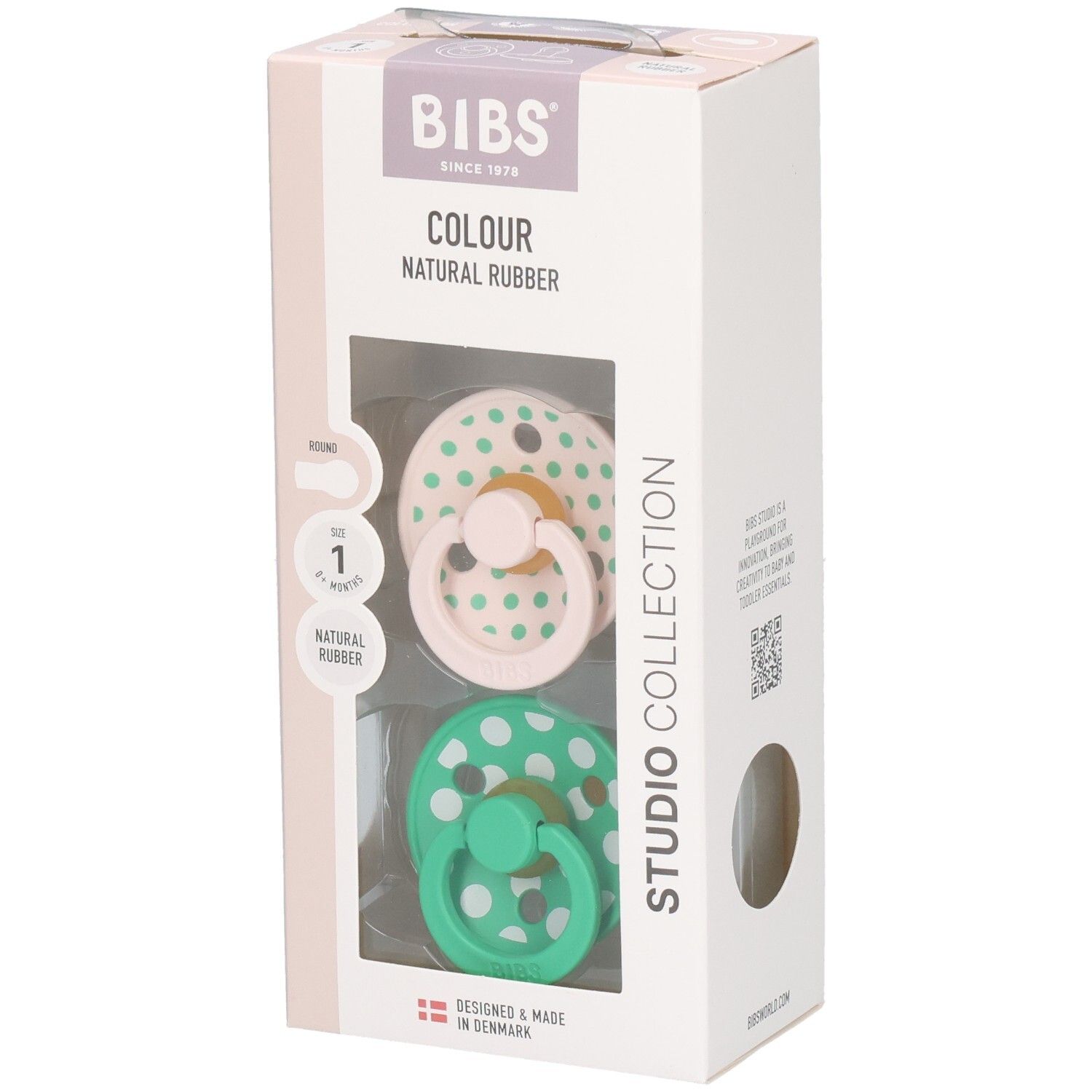 Boîte avec deux sucettes. Sucettes roses et vertes à pois blancs. Marque : BIBS. Caoutchouc naturel.