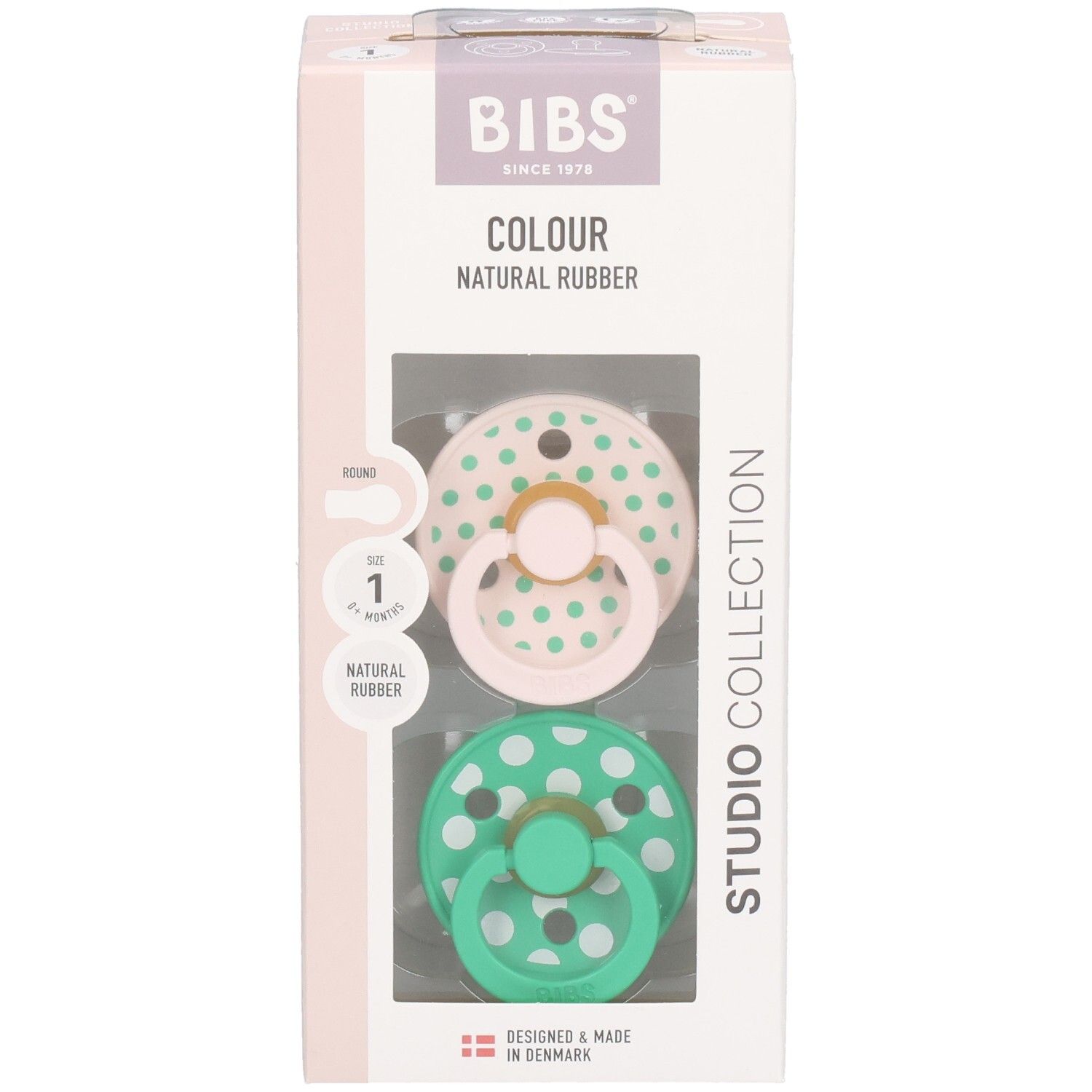 Boîte avec deux sucettes. Sucettes roses et vertes à pois blancs. Marque : BIBS. Caoutchouc naturel.