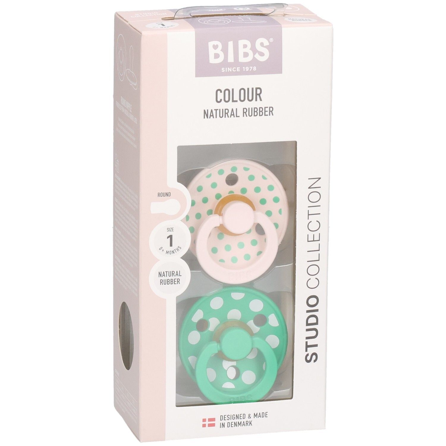 Boîte avec deux sucettes. Sucettes roses et vertes à pois blancs. Marque : BIBS. Caoutchouc naturel.