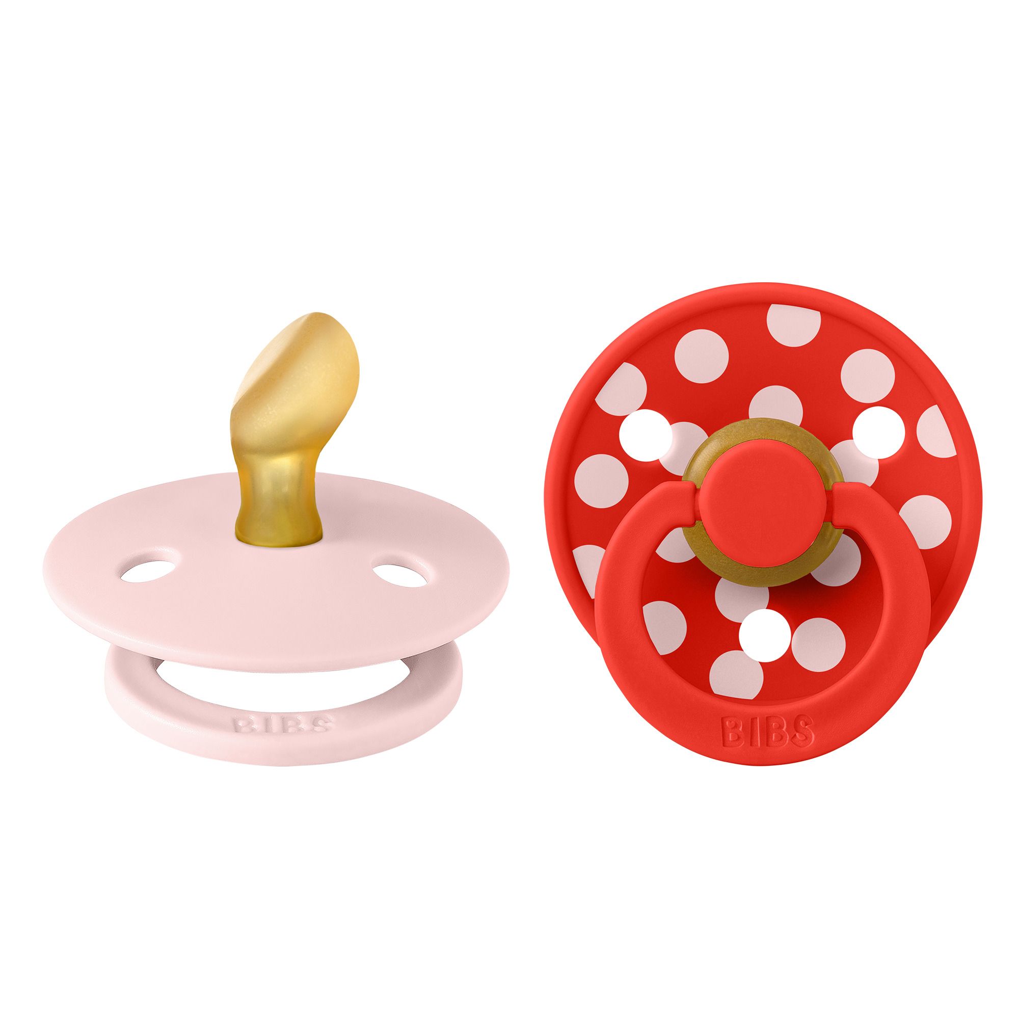 Deux sucettes BIBS: rose à pois blancs, anatomique. Rouge à pois blancs, anatomique.