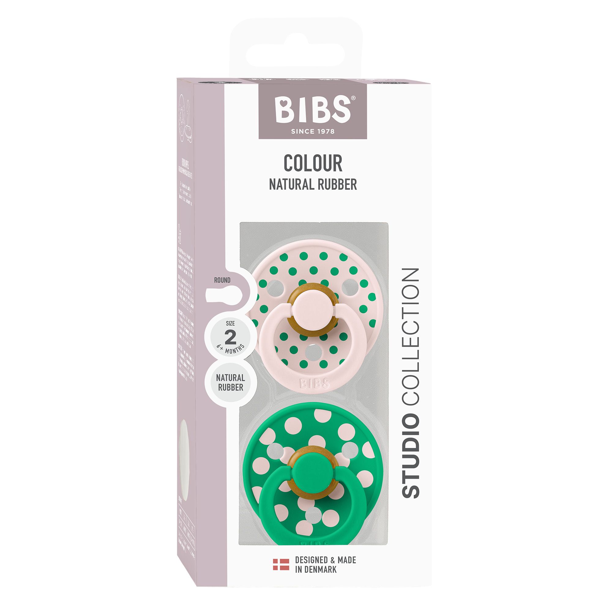 Boîte de deux sucettes. Sucettes roses et vertes à pois blancs. Marque : BIBS. Caoutchouc naturel.