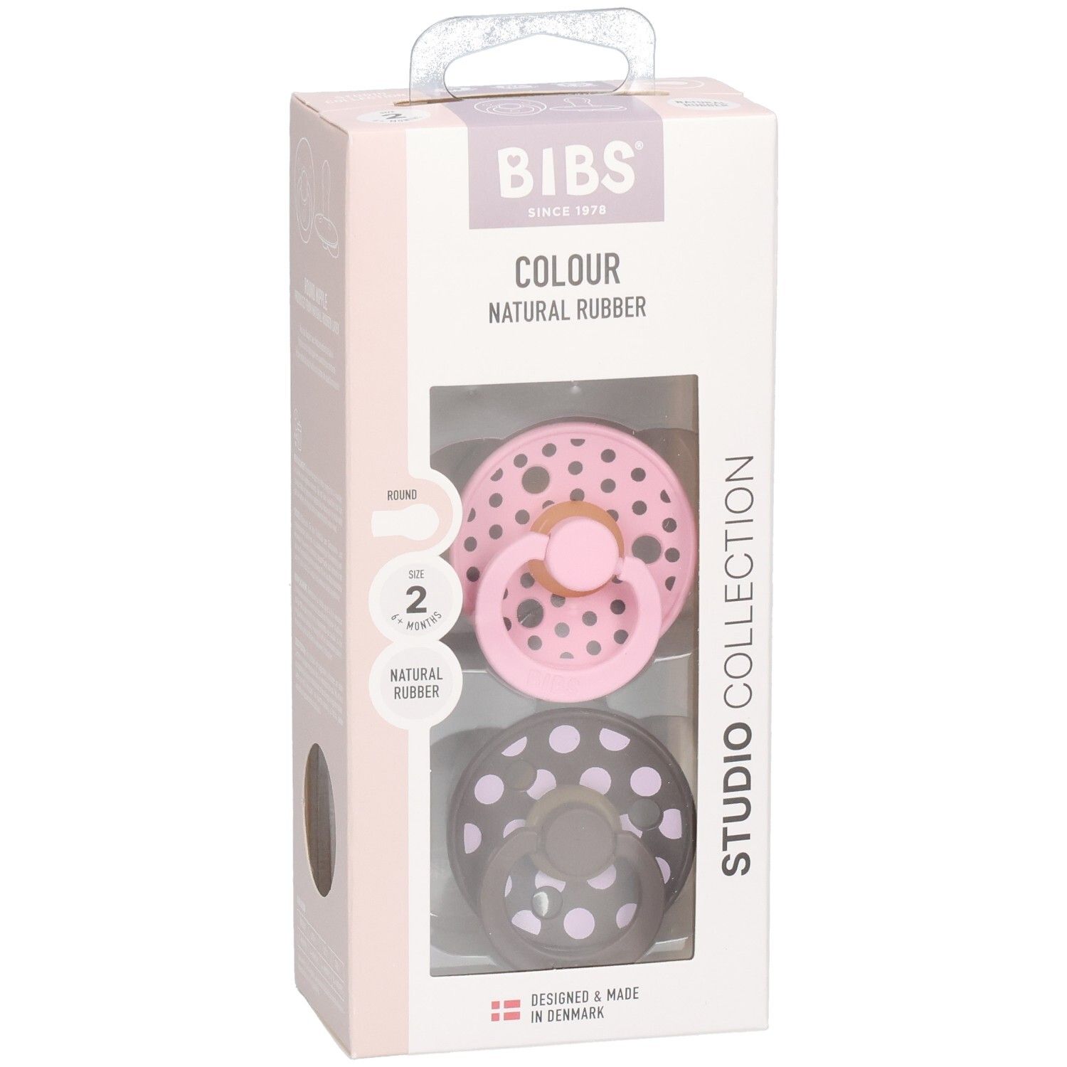 Emballage de deux sucettes. Rose et gris à pois blancs. Marque : BIBS. Texte : Colour, Natural Rubber, Studio Collection.