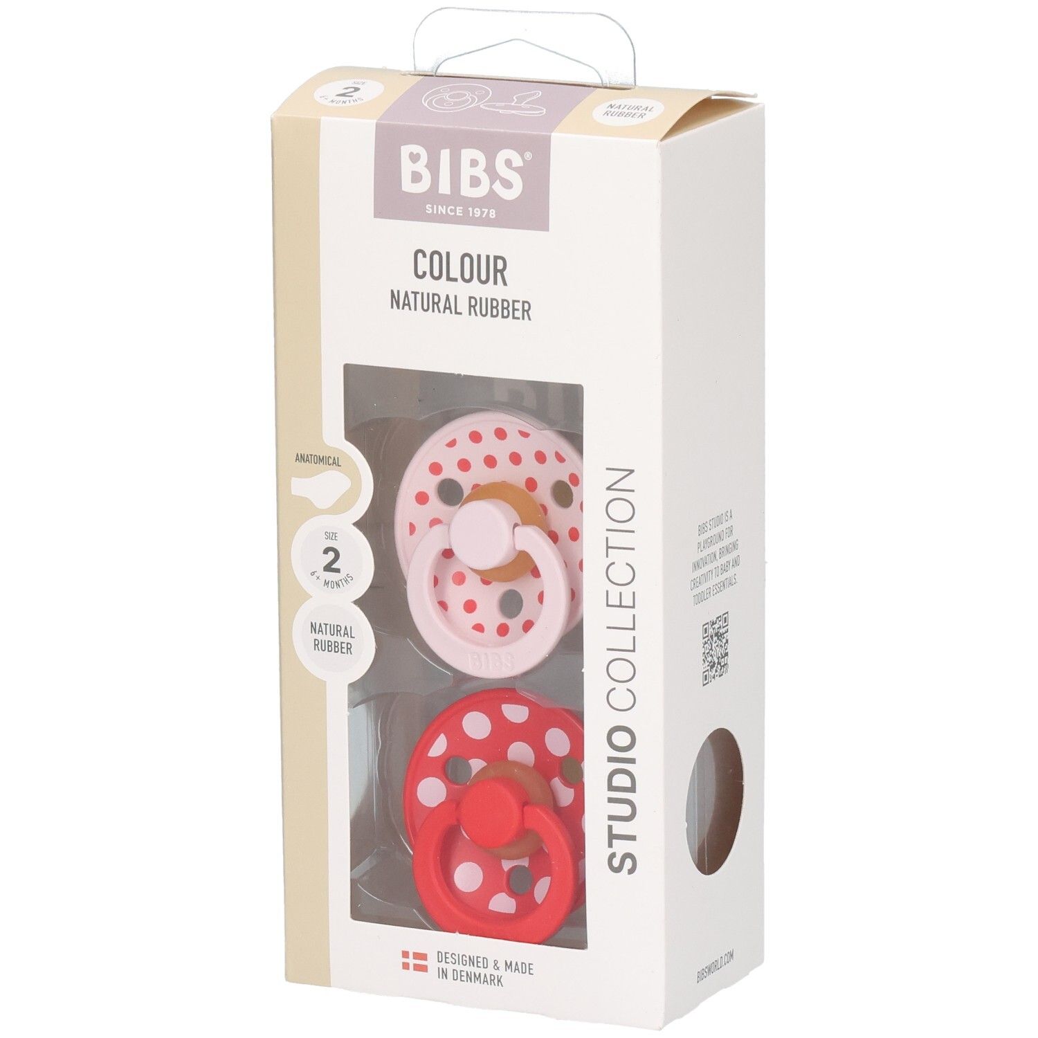 Boîte contenant deux sucettes. Sucettes rose et rouge à pois blancs. Logo BIBS et informations sur le produit.