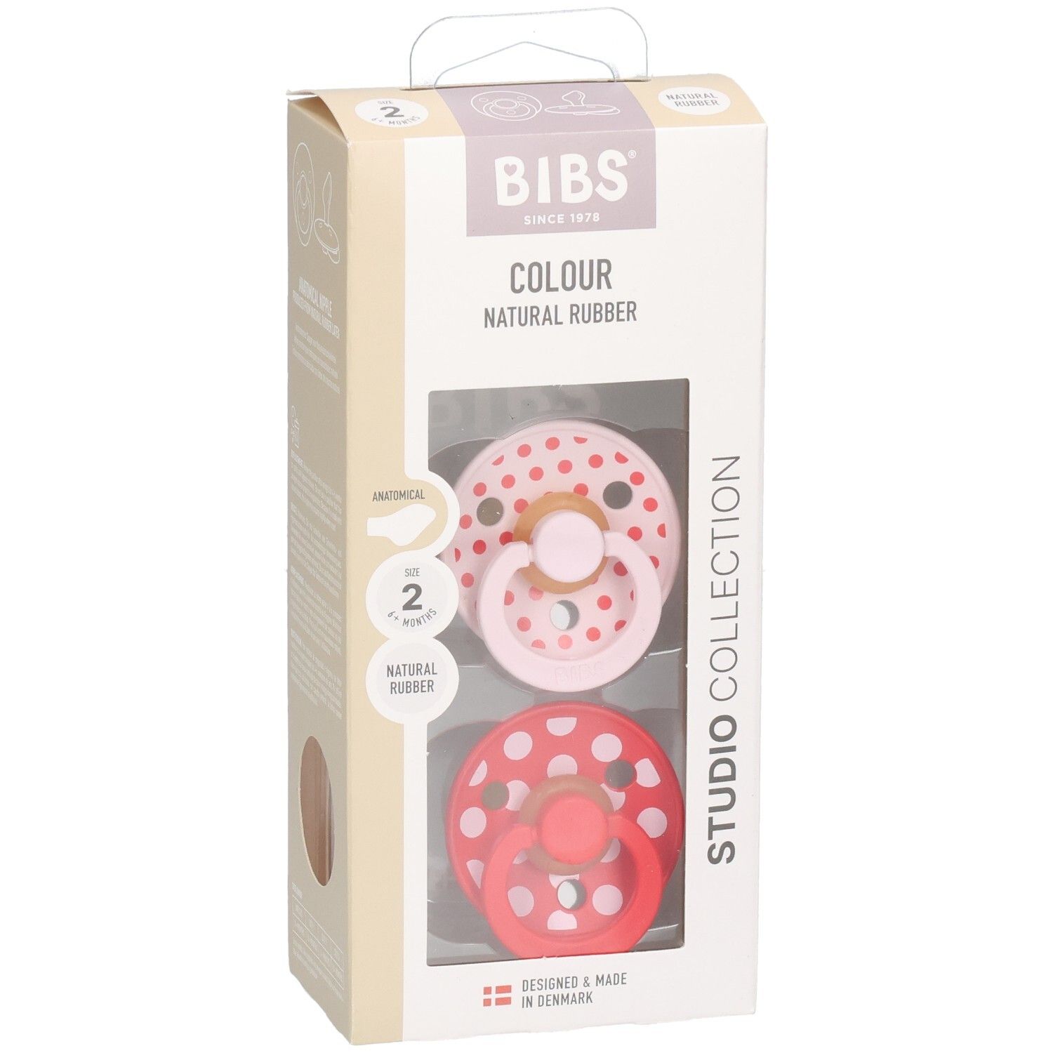 Boîte contenant deux sucettes. Sucettes rose et rouge à pois blancs. Logo BIBS et informations sur le produit.