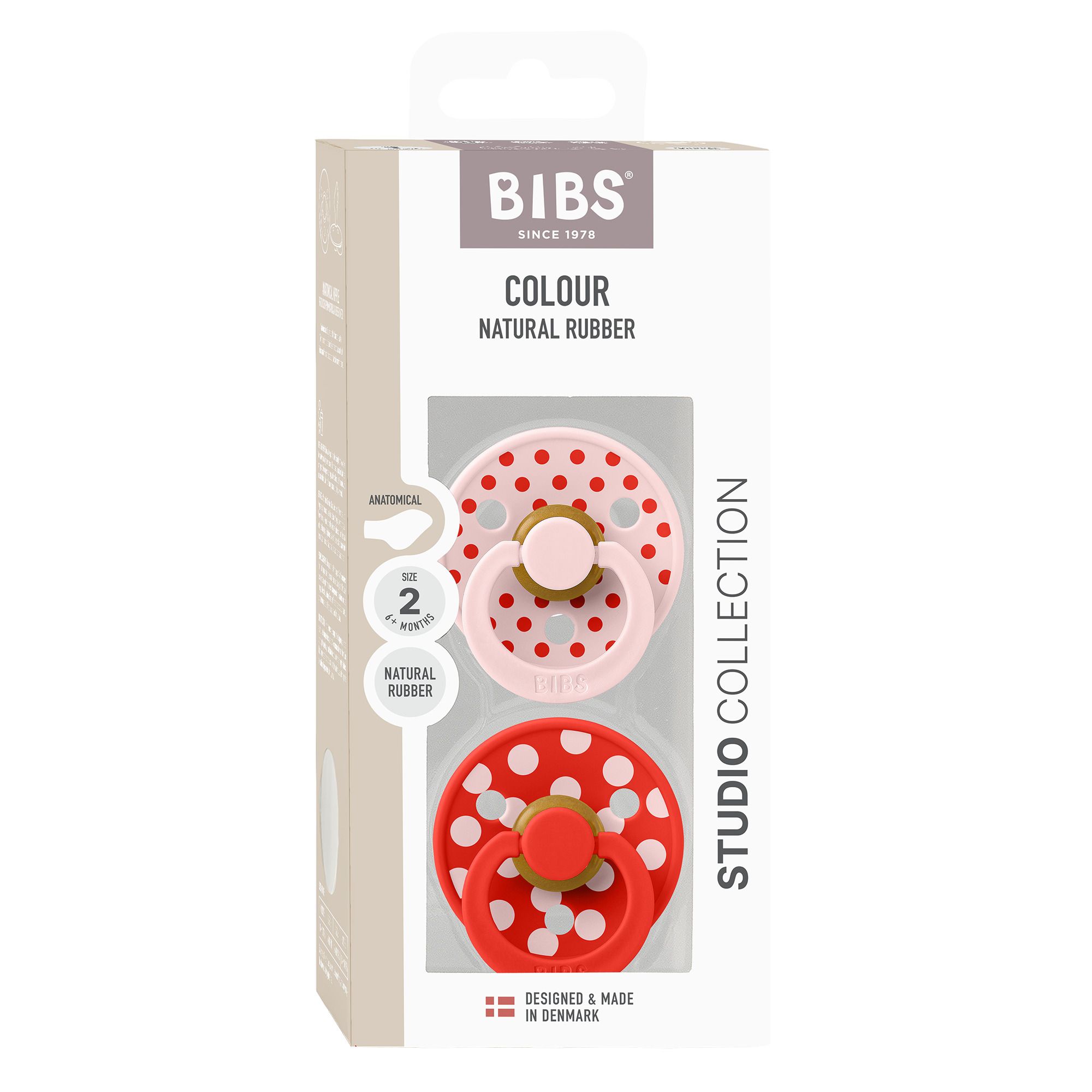 Boîte contenant deux sucettes. Sucettes rose et rouge à pois blancs. Logo BIBS et informations sur le produit.