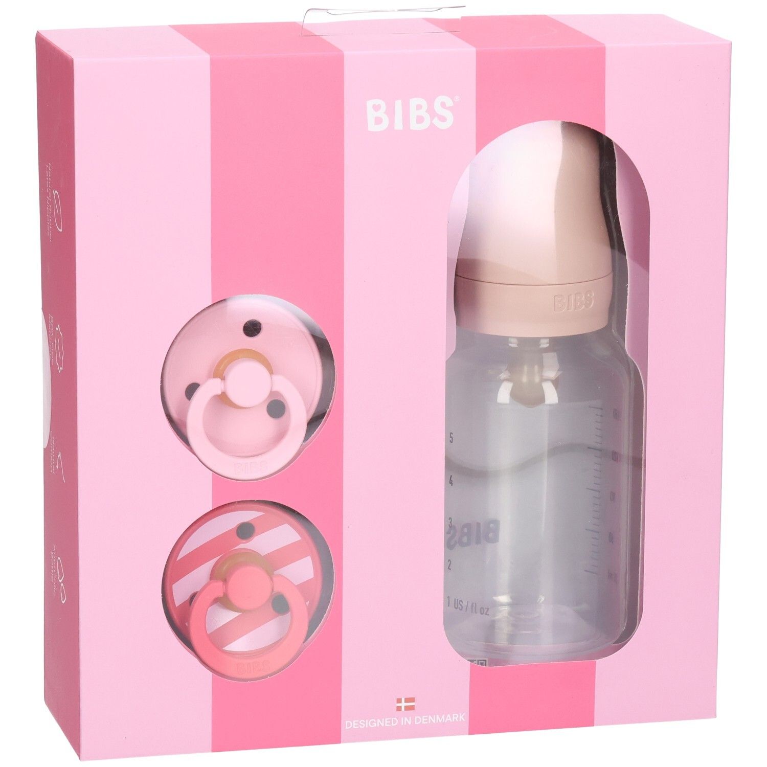 Coffret rose avec sucettes et biberon. Logo BIBS. Biberon transparent avec graduation. Deux sucettes.