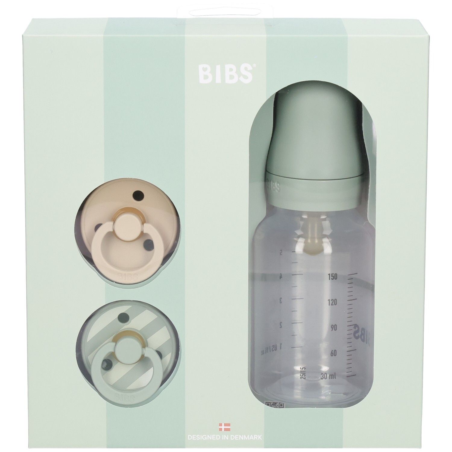 Coffret cadeau avec deux sucettes et un biberon dans une boîte. Le biberon a une échelle de mesure.