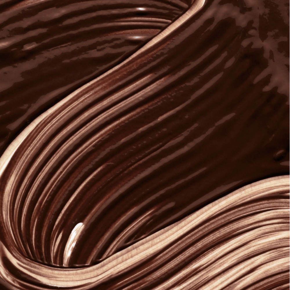 Gros plan d'une crème brune lisse et brillante, formée en vagues.