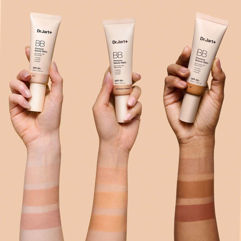 Mains aux teints variés tenant Dr.Jart+ BB Cream.