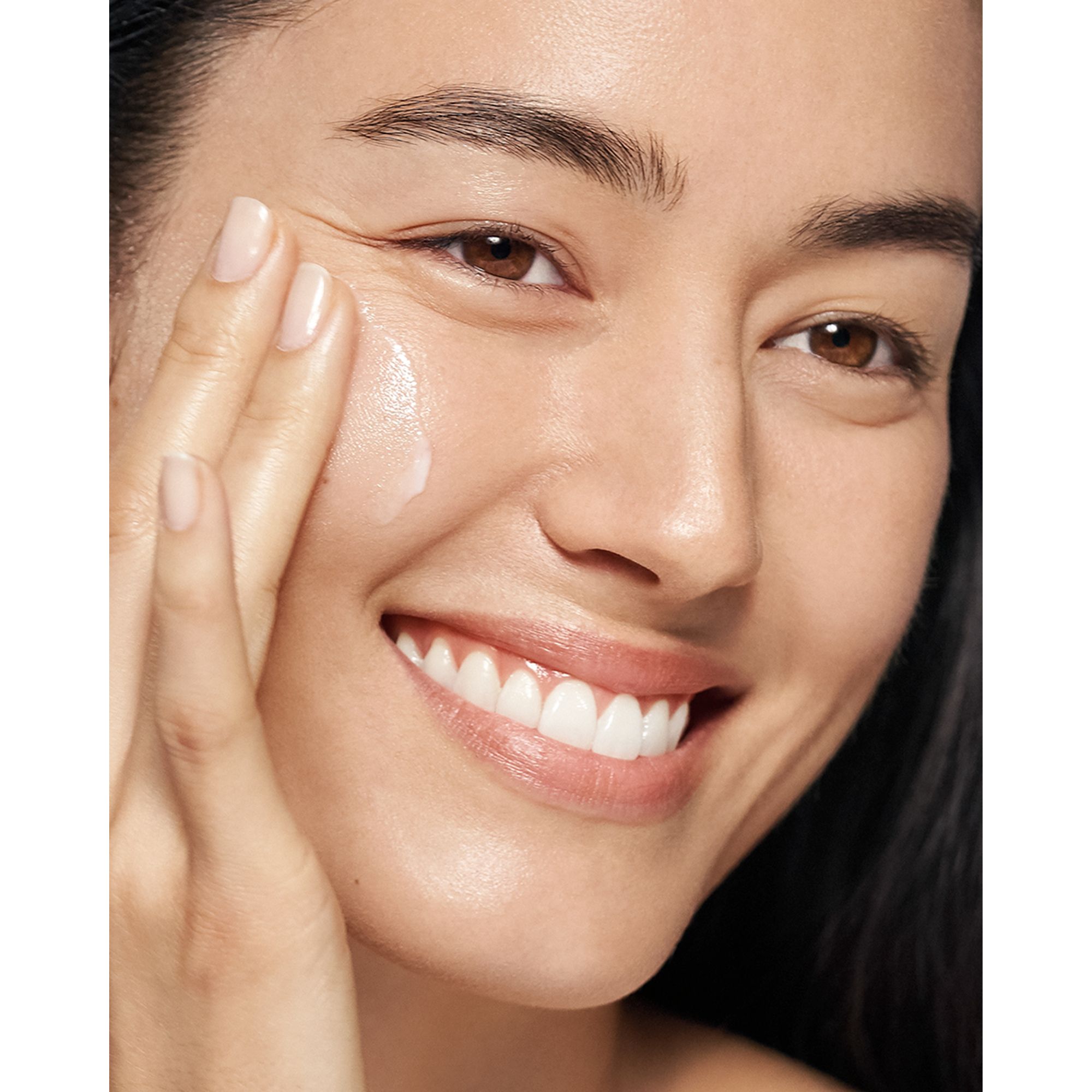 Femme appliquant de la crème. Visage d'une femme. Clinique Moisture Surge Intense 72H.