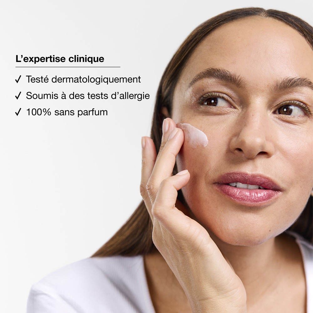 Une femme applique une crème sur son visage, mettant en avant l'expertise clinique.