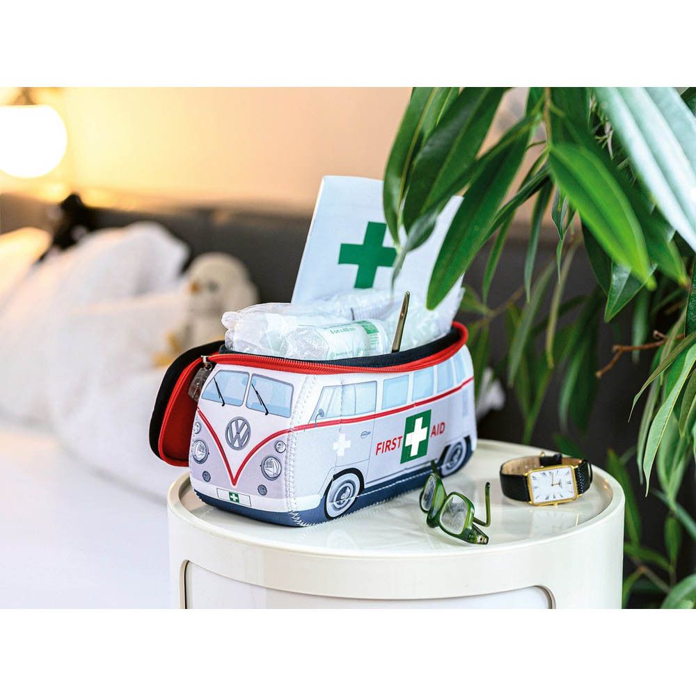 Trousse de premiers soins en combi VW, vue latérale avec "First Aid" et croix.