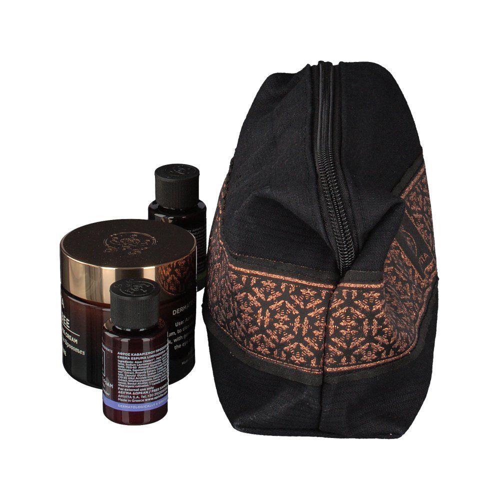 Trousse de toilette noire avec motif marron, partiellement ouverte. Produits : crème, lotion, mousse nettoyante. Marque : APIVITA.