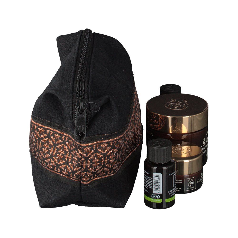 Trousse de toilette noire avec motif marron et produits. Produits : crème, lotion, mousse nettoyante. Marque : APIVITA.