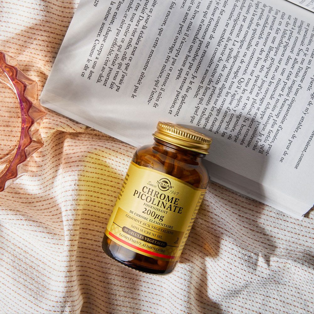 Flacon brun sur un livre. Étiquette du produit visible. Arrière-plan flou.