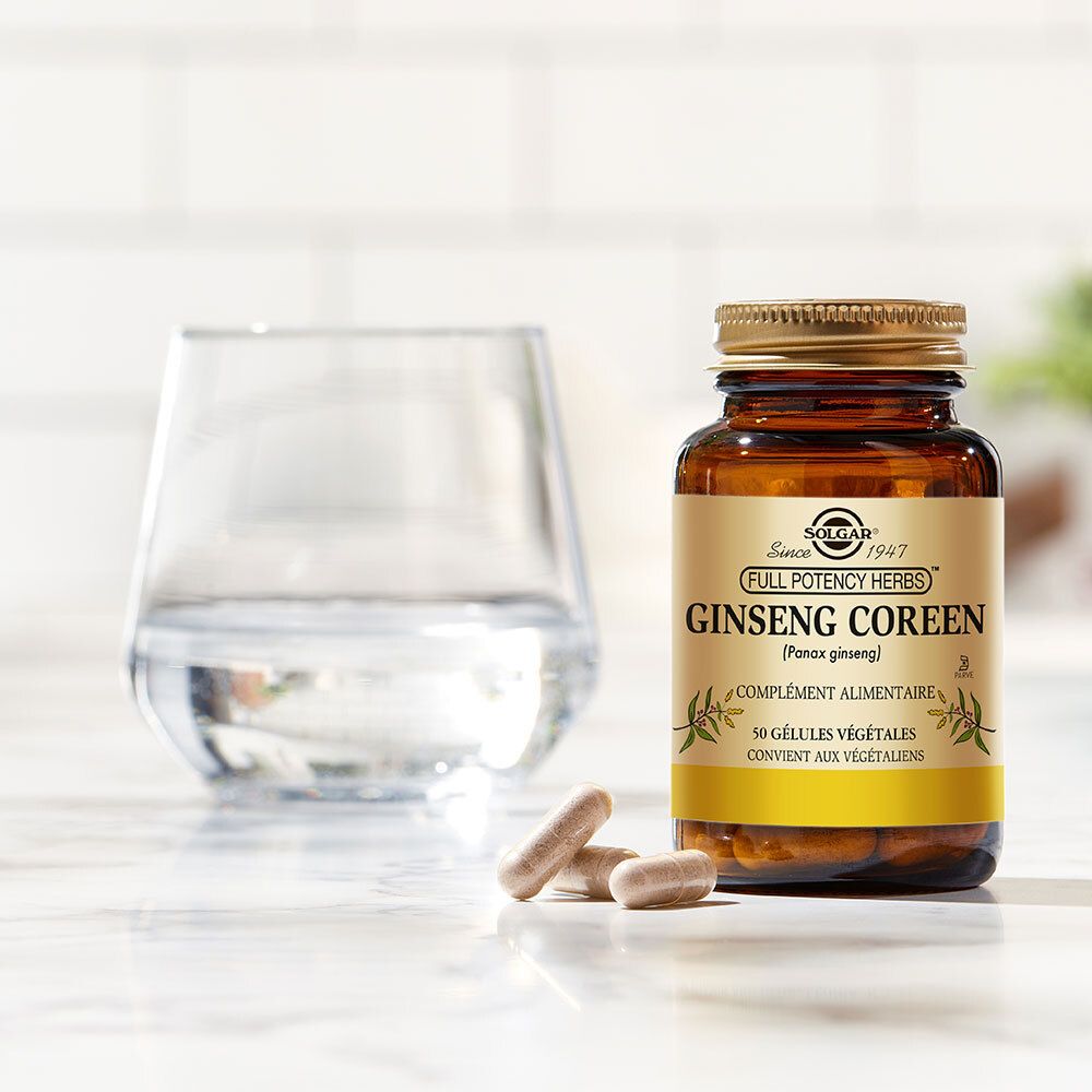 Flacon brun avec bouchon doré et trois gélules à côté. Un verre d'eau est à gauche.