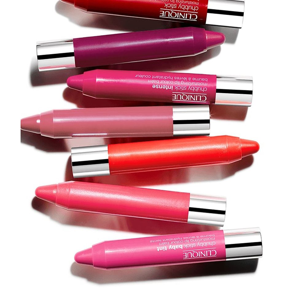 Sept baumes à lèvres Clinique Chubby Stick Intense de différentes couleurs. Bouchons argentés, vue de dessus.