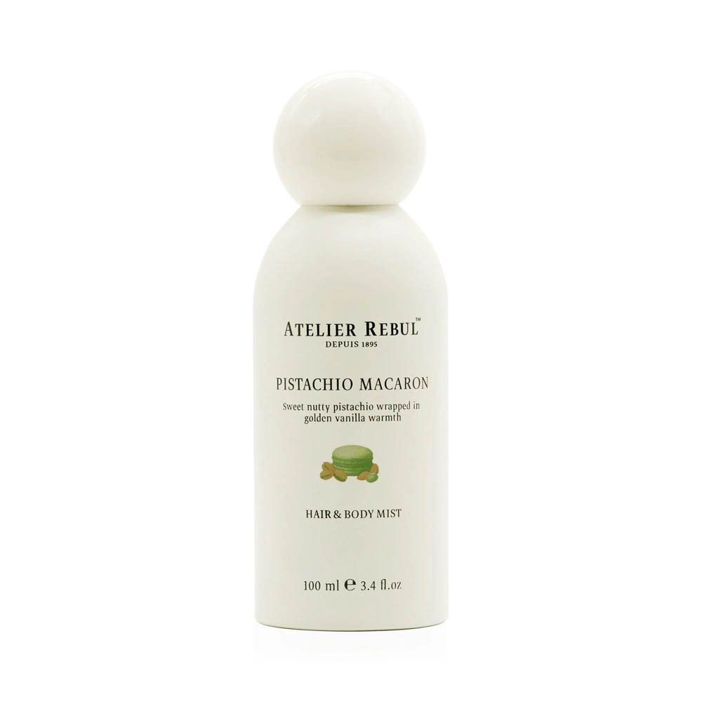 Flacon blanc avec bouchon rond. Inscription : ATELIER REBUL, PISTACHIO MACARON, HAIR & BODY MIST. 100 ml.
