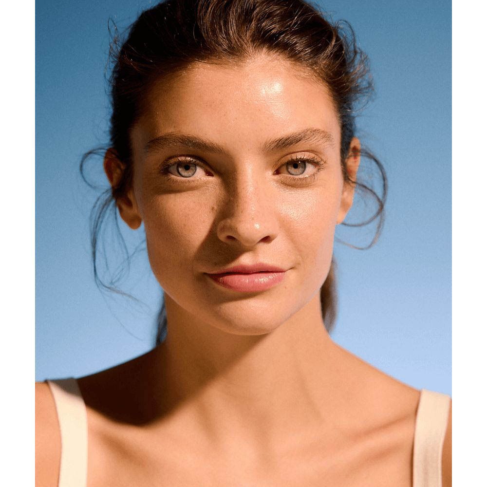 Portrait d'une femme à la peau impeccable utilisant l'eau micellaire NIVEA Rose Care.