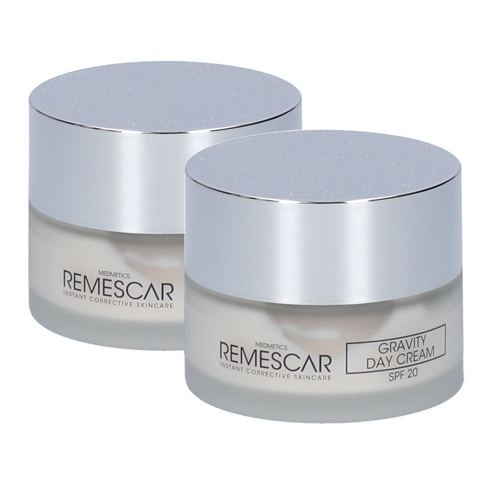 Deux pots de crème avec couvercles argentés. Inscription: REMESCAR, GRAVITY DAY CREAM SPF 20. Récipients en verre avec substance crémeuse.