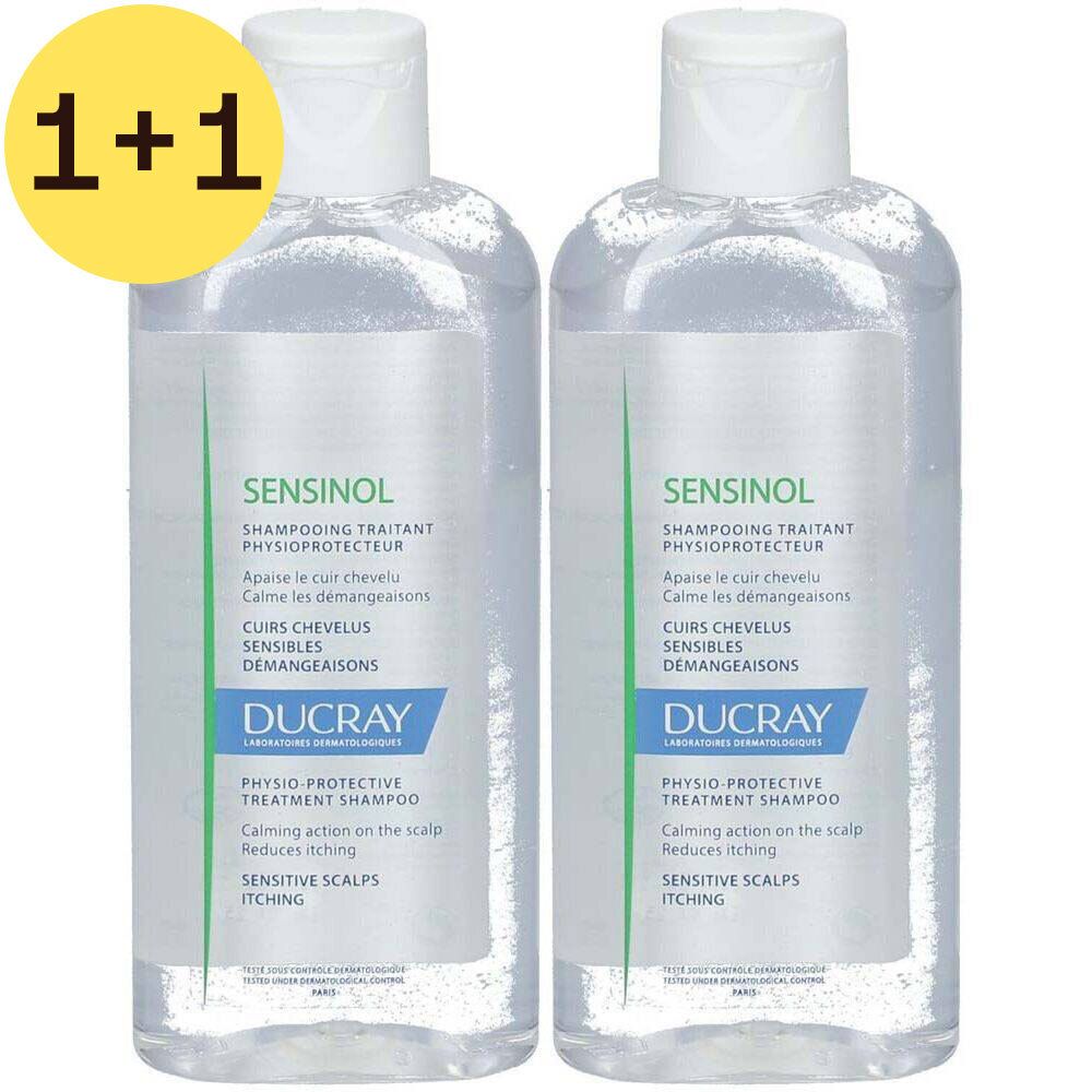 Deux flacons transparents de shampooing avec bouchon blanc. Inscription "SENSINOL" et "DUCRAY" sur chaque flacon. Autocollant jaune "1+1".