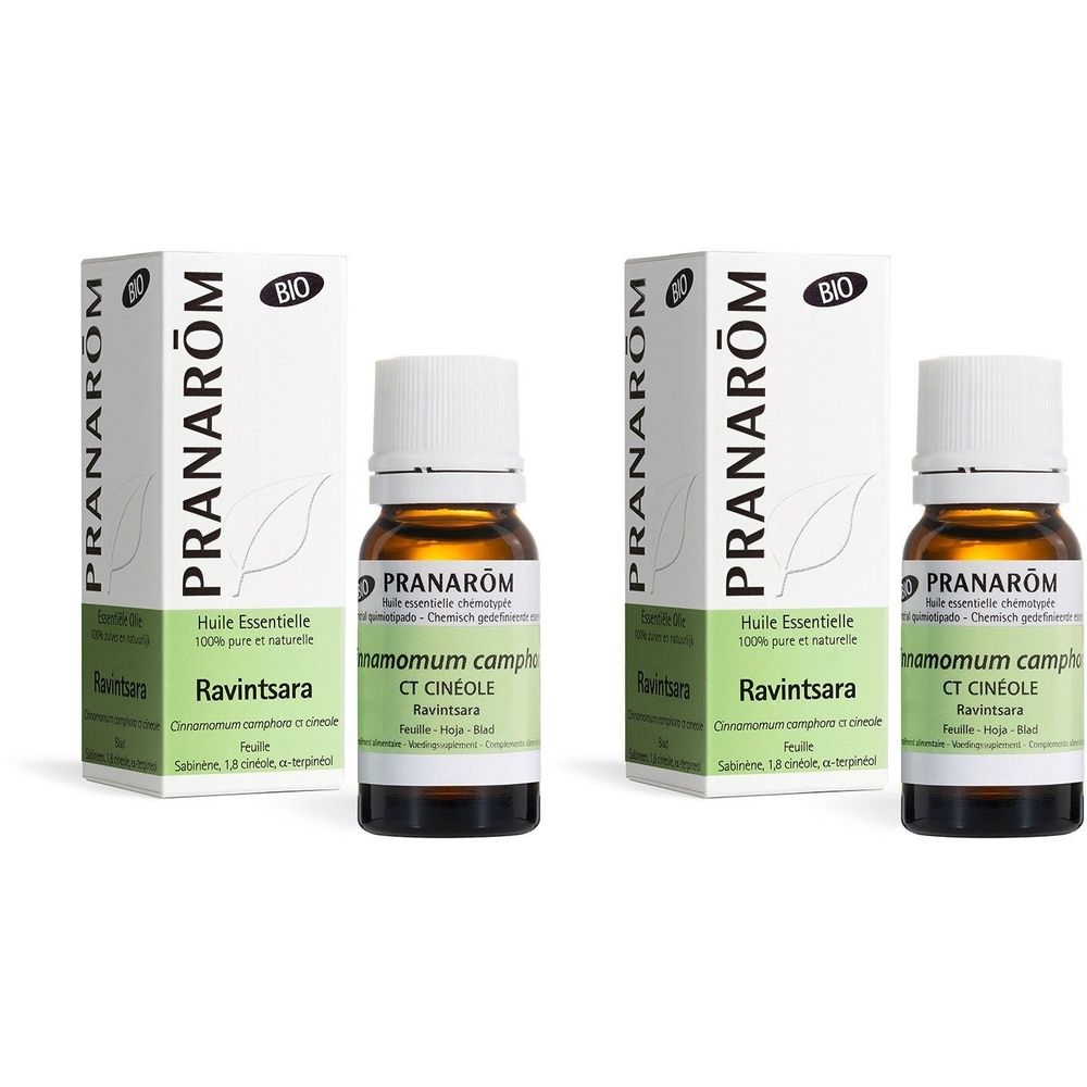 Deux flacons et deux boîtes de PRANAROM Ravintsara. Flacons en verre brun avec bouchon blanc. Boîtes avec logo et informations produit.