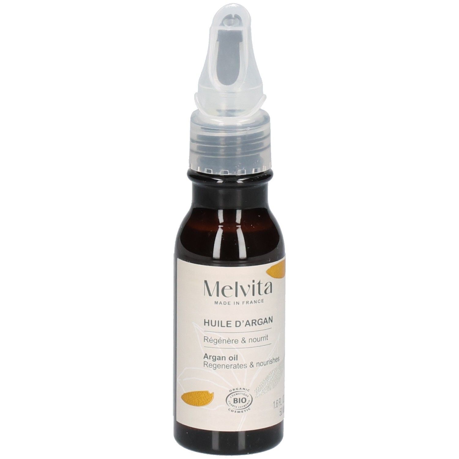 Flacon d'huile d'argan Melvita avec applicateur, entouré de fruits d'argan.