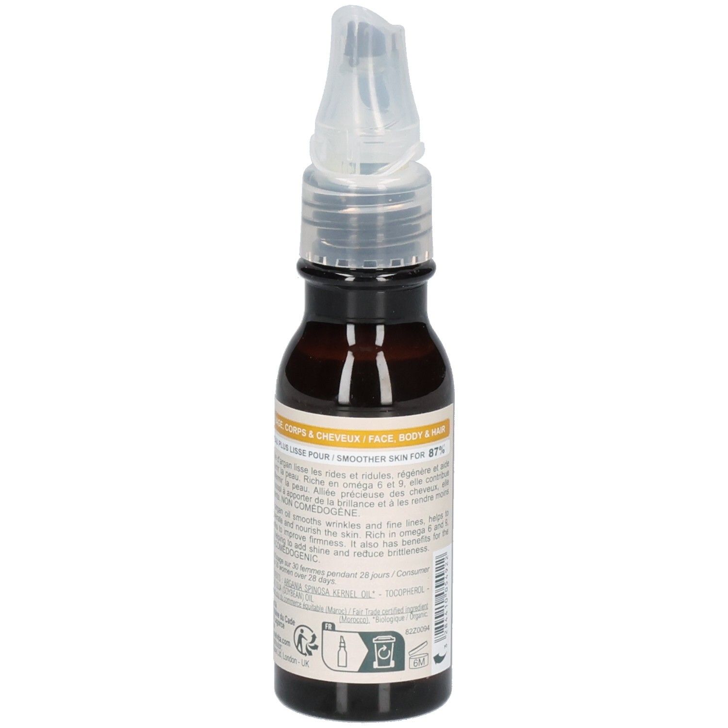 Flacon d'huile d'argan Melvita avec applicateur, entouré de fruits d'argan. "100% pur, pressé à froid".