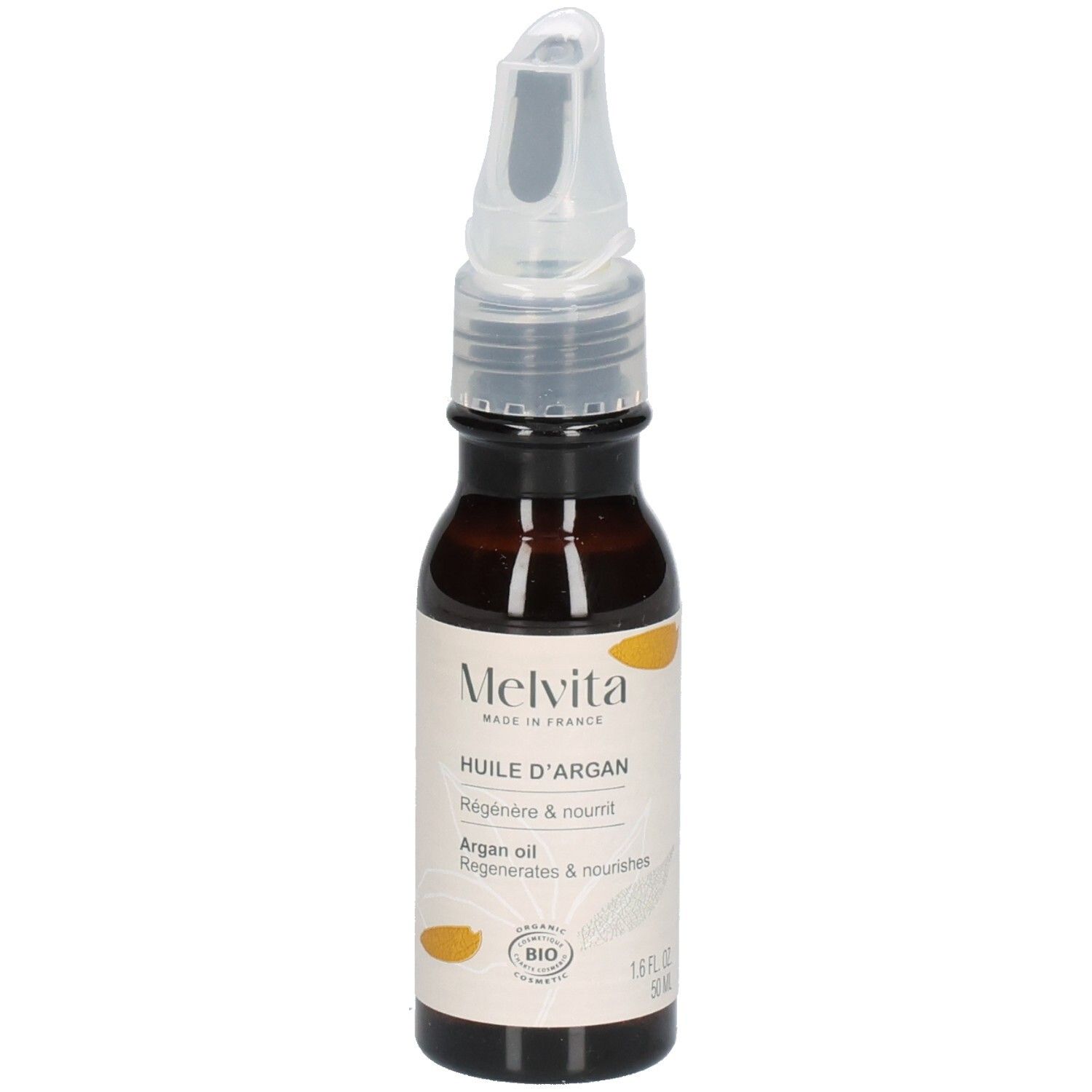 Flacon d'huile d'argan Melvita avec applicateur sur terre, entouré de plantes. "Flacon recyclable".