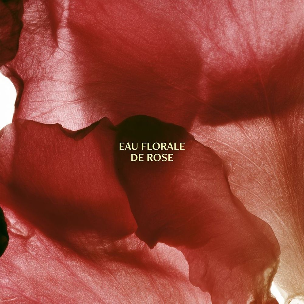 Représentation abstraite de pétales de rose rouges avec le texte "EAU FLORALE DE ROSE".