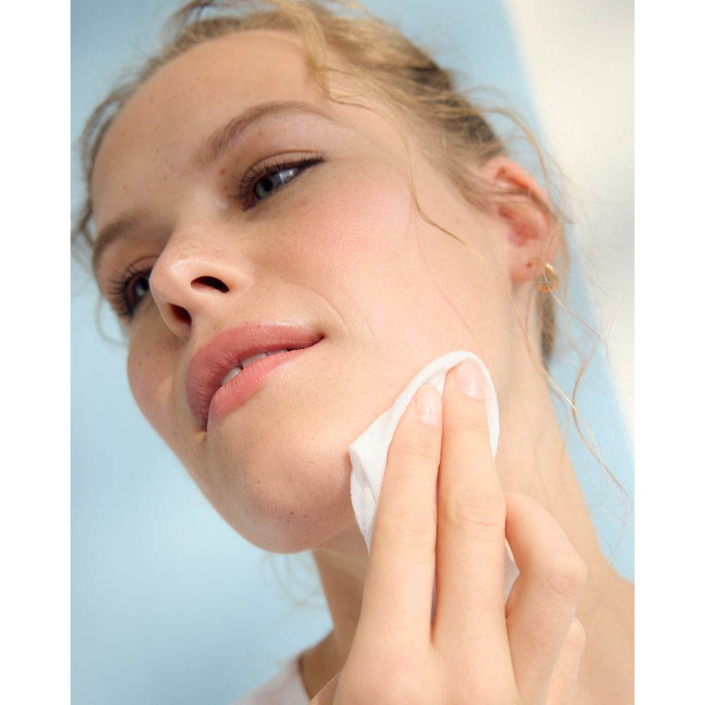 Femme utilisant une lingette démaquillante Nivea sur son visage.