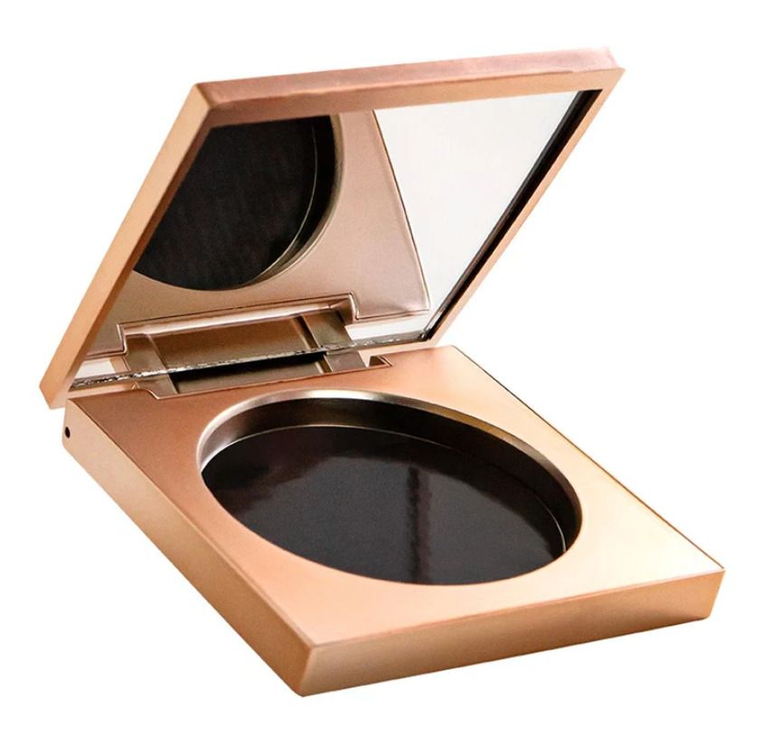 Palette rechargeable dorée, ouverte, avec miroir et compartiment vide. Vue en biais.