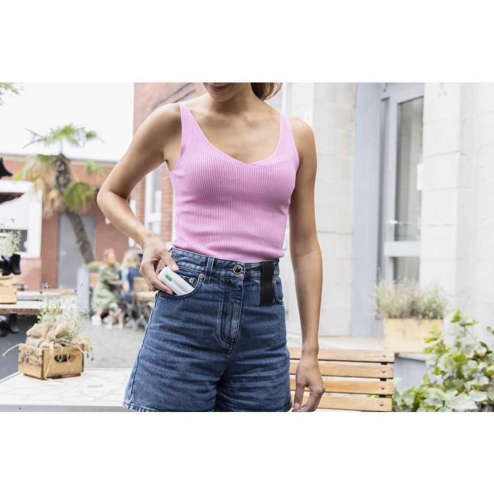 Femme met un appareil blanc dans sa poche. Short en jean.