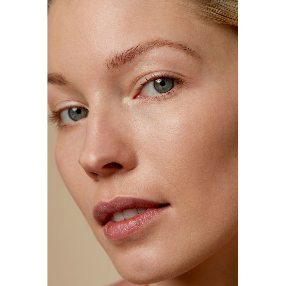 Gros plan d'un visage avec une peau couverte de fond de teint.