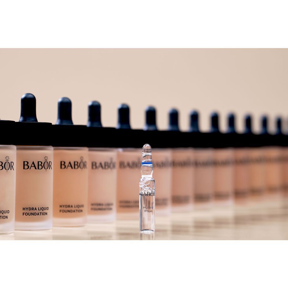 Rangée de flacons de fond de teint avec pipettes. Une ampoule au premier plan. Marque BABOR, produit HYDRA LIQUID FOUNDATION.