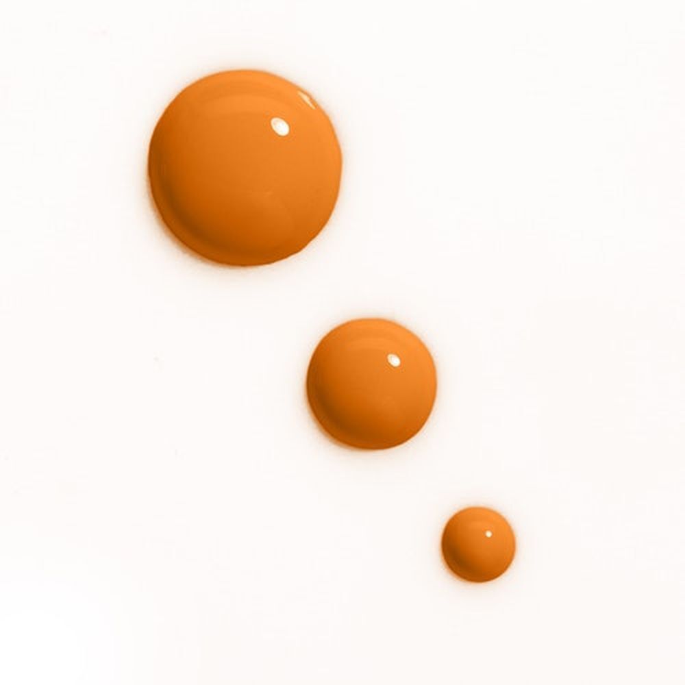 Trois gouttes orange. Sur fond blanc. Gouttes de différentes tailles.