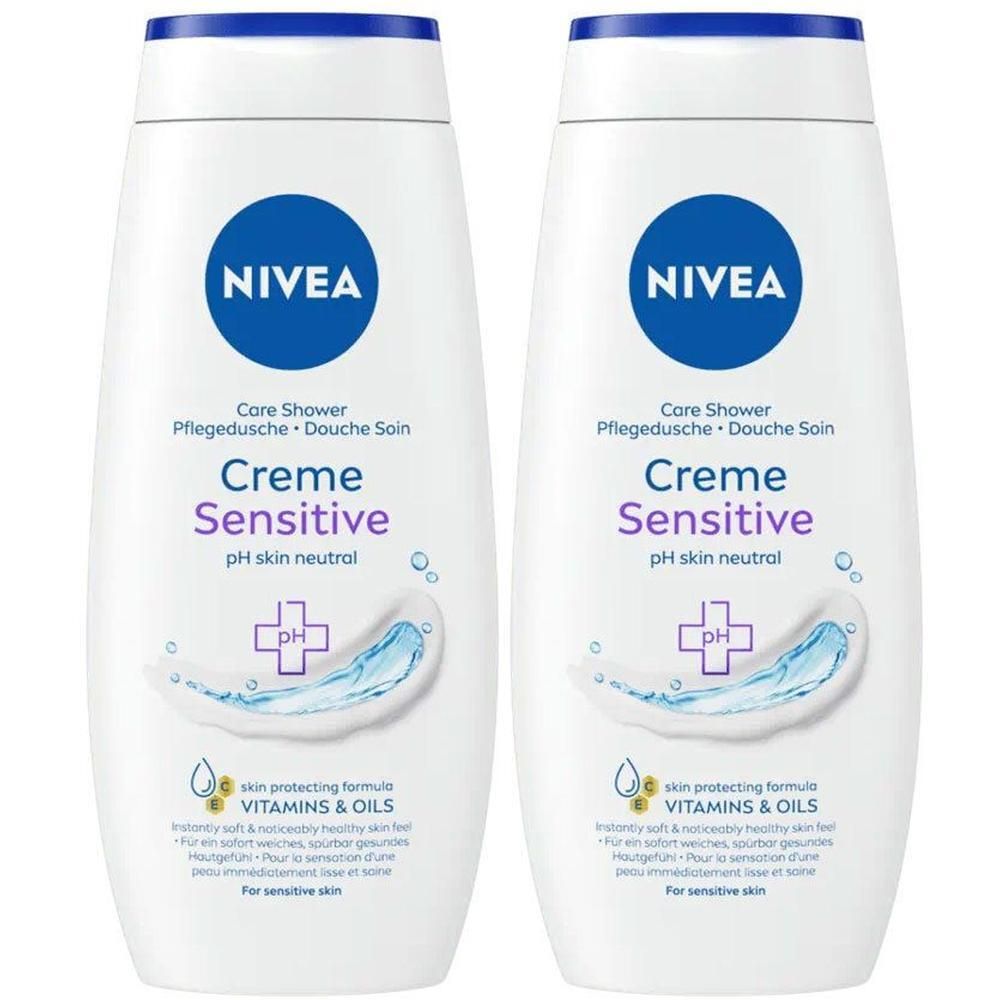 Deux flacons blancs de gel douche avec bouchon bleu. Inscription: NIVEA, Creme Sensitive, pH neutre pour la peau. Image d'eau et logo.