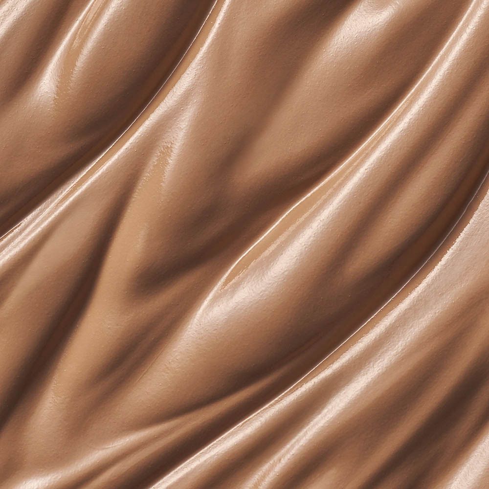 Gros plan d'une substance crémeuse brune. La surface est ondulée et brillante.
