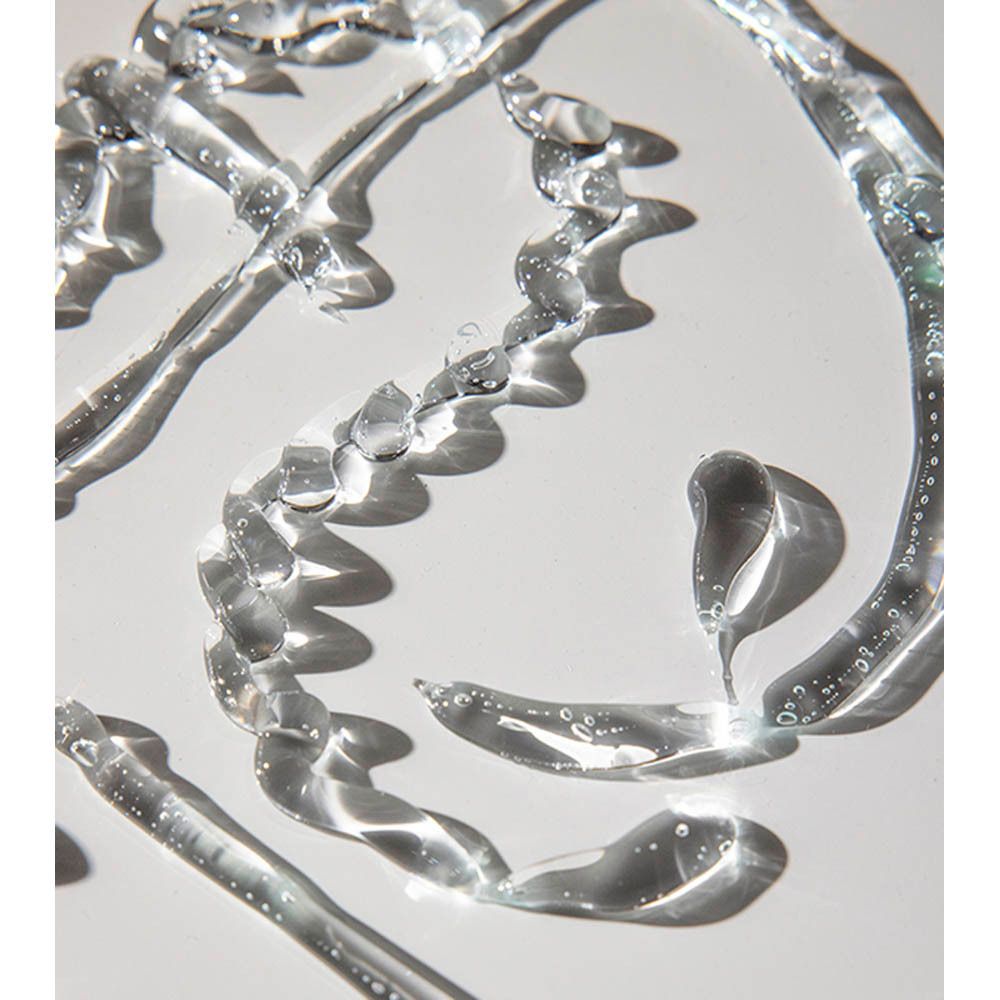 Gouttes de gel transparentes sur fond blanc. Plusieurs gouttes de formes différentes.