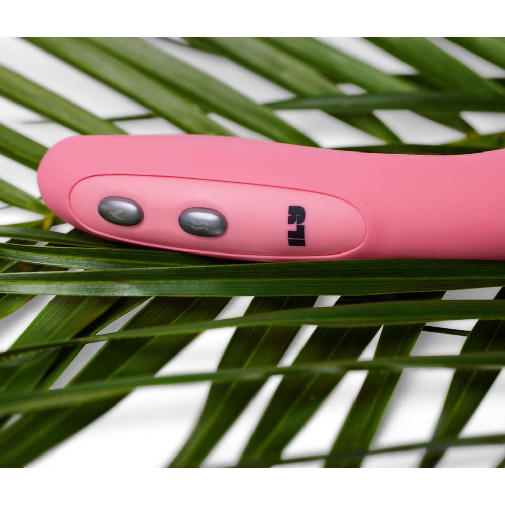 Vibrateur rose sur feuilles de palmier. Trois boutons visibles. Marque ILS.