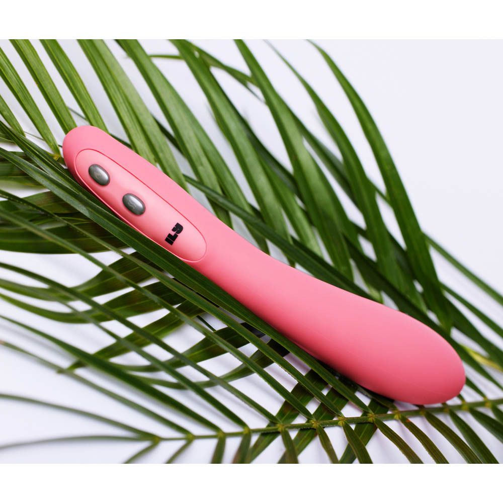 Vibrateur rose sur feuilles de palmier. Trois boutons visibles. Marque ILS.