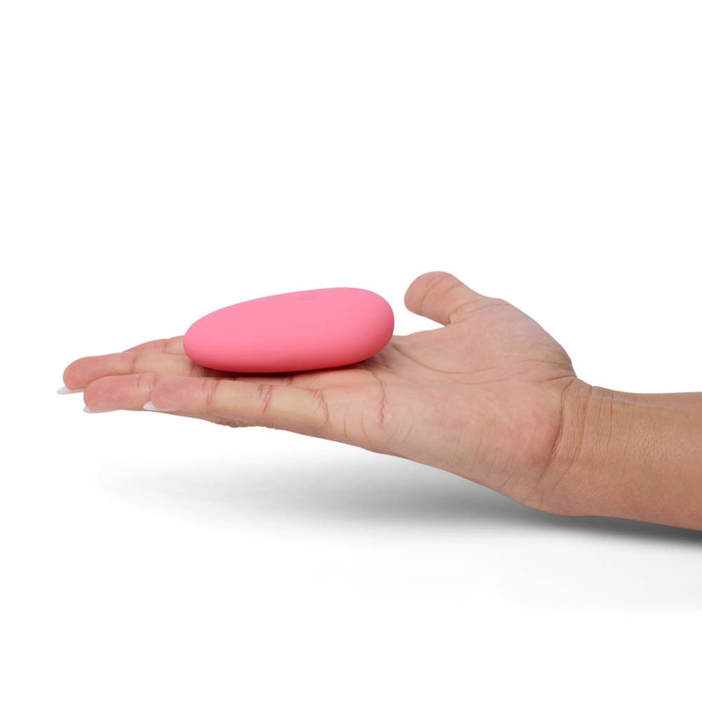 Paume avec vibrateur rose en forme d'œuf. Logo: ILS. Surface lisse.